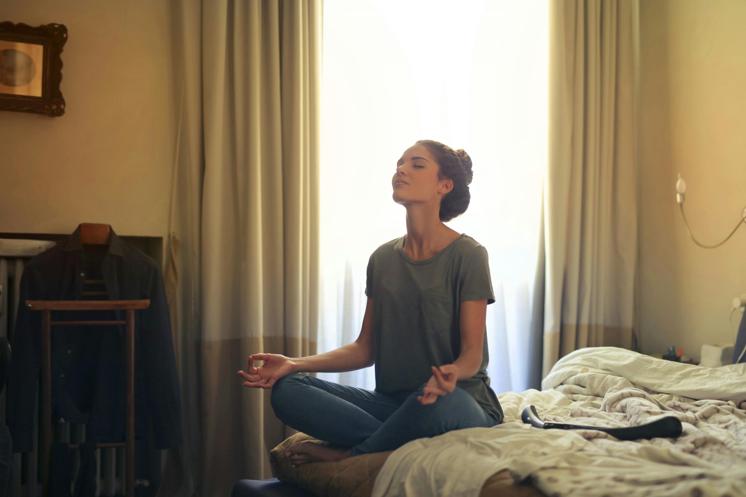 woman meditating on bed