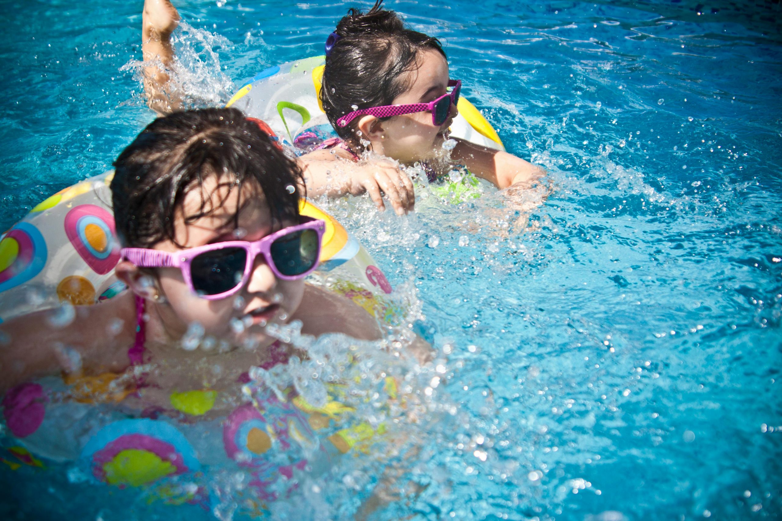 Two kids swimming in a swimming pool