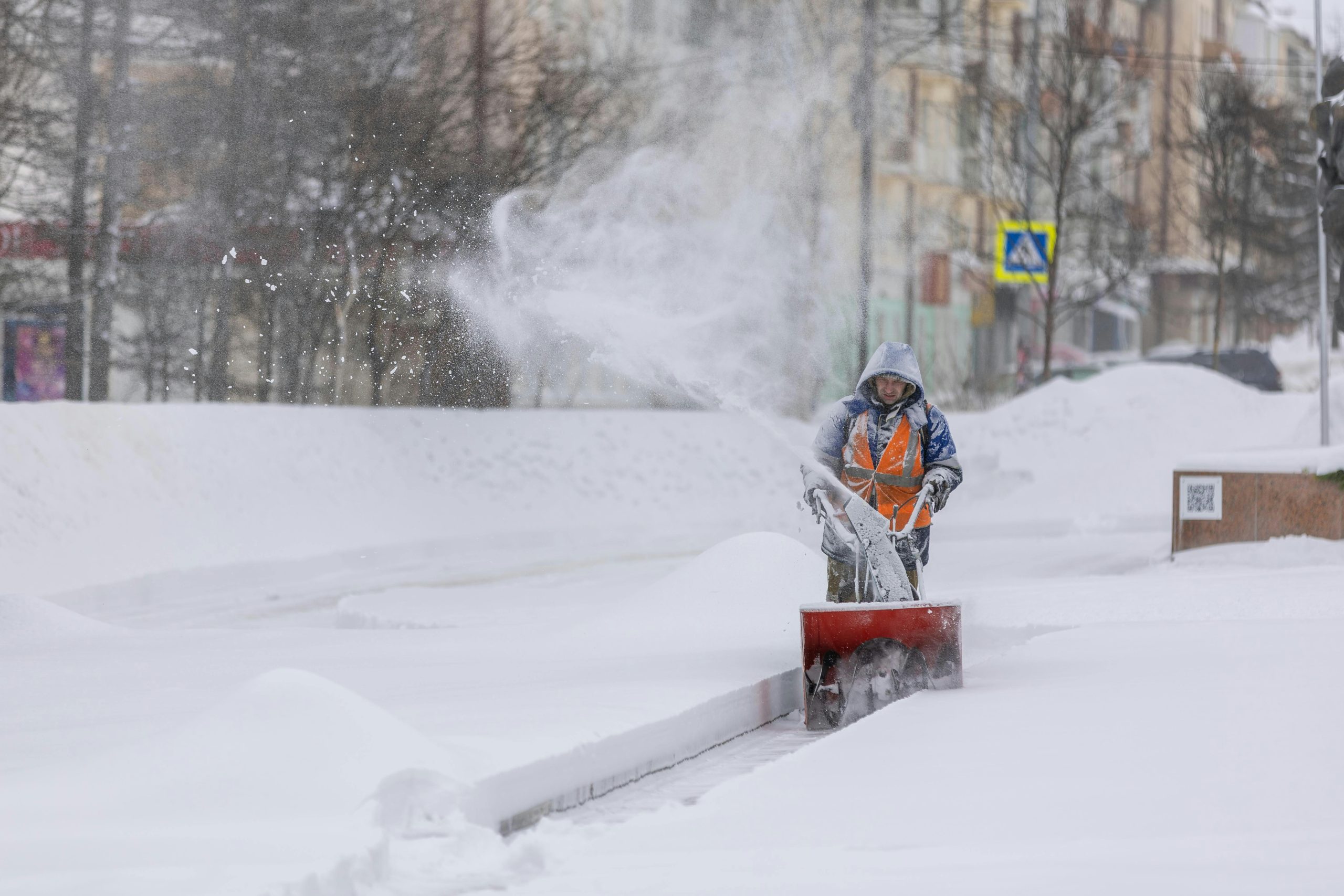 A person using a snowblower in winter